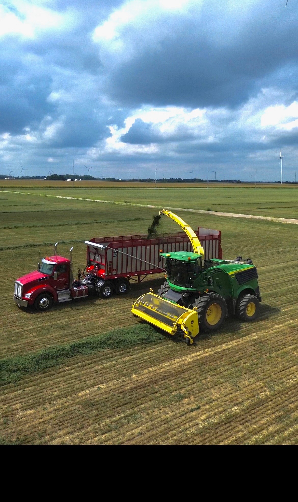 John Deere Tractor with Auger Wagon / Grain Cart Dumping Crop into Hopper Trailer