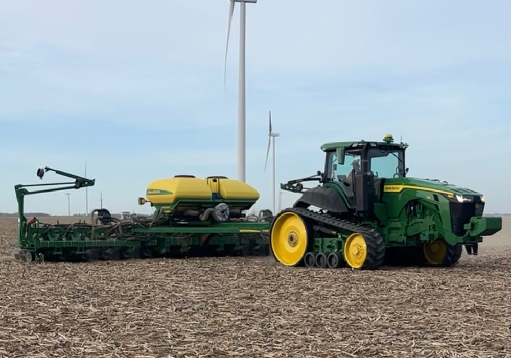 John Deere tractor pulling a planter in a field