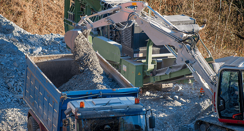 Excavator Loading Rocks into Heavy-Duty Dump Truck